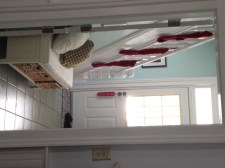 A hallway with three red stockings hung on a bannister.