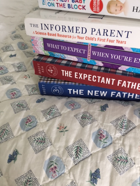 Stack of baby books on a bed